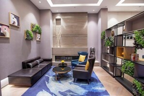 A modern living room with a sofa, armchair, coffee table, and bookshelf.