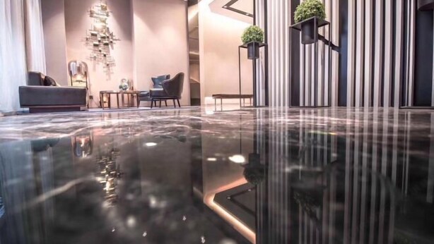 A modern lobby with a reflective floor, a seating area with sofas and a coffee table, and vertical striped walls with potted plants. - Homeinn Selected Hotel (Chongqing Jiefangbei Area Hong Ya Dong Pedestrian Street) (Chongqing)