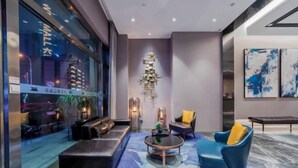 A modern living room with a sofa, armchair, and coffee table. There is a large window with a view of buildings outside. - Homeinn Selected Hotel (Chongqing Jiefangbei Area Hong Ya Dong Pedestrian Street) (Chongqing)