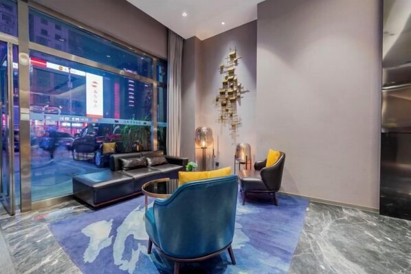A modern lounge area with a sofa, armchairs, and a coffee table.