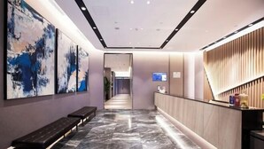 A modern hotel lobby with a marble floor, a reception desk, and abstract art on the walls. - Homeinn Selected Hotel (Chongqing Jiefangbei Area Hong Ya Dong Pedestrian Street) (Chongqing)