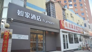 Un hotel con un letrero que dice "Homeinn" y otro letrero que indica "Jiangsu Hotel".