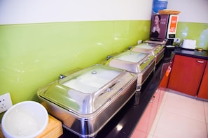A buffet setup with stainless steel chafing dishes and a water dispenser.