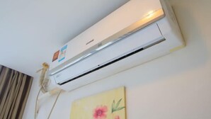 A white air conditioning unit mounted on a wall with a control panel and a power cord. - 99 Inn (Shanghai Railway Station No.1 branch) (Shanghai)