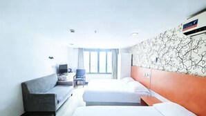 A hotel room with a bed, a sofa, a desk, and a chair. - 99 Inn (Shanghai Railway Station No.1 branch) (Shanghai)