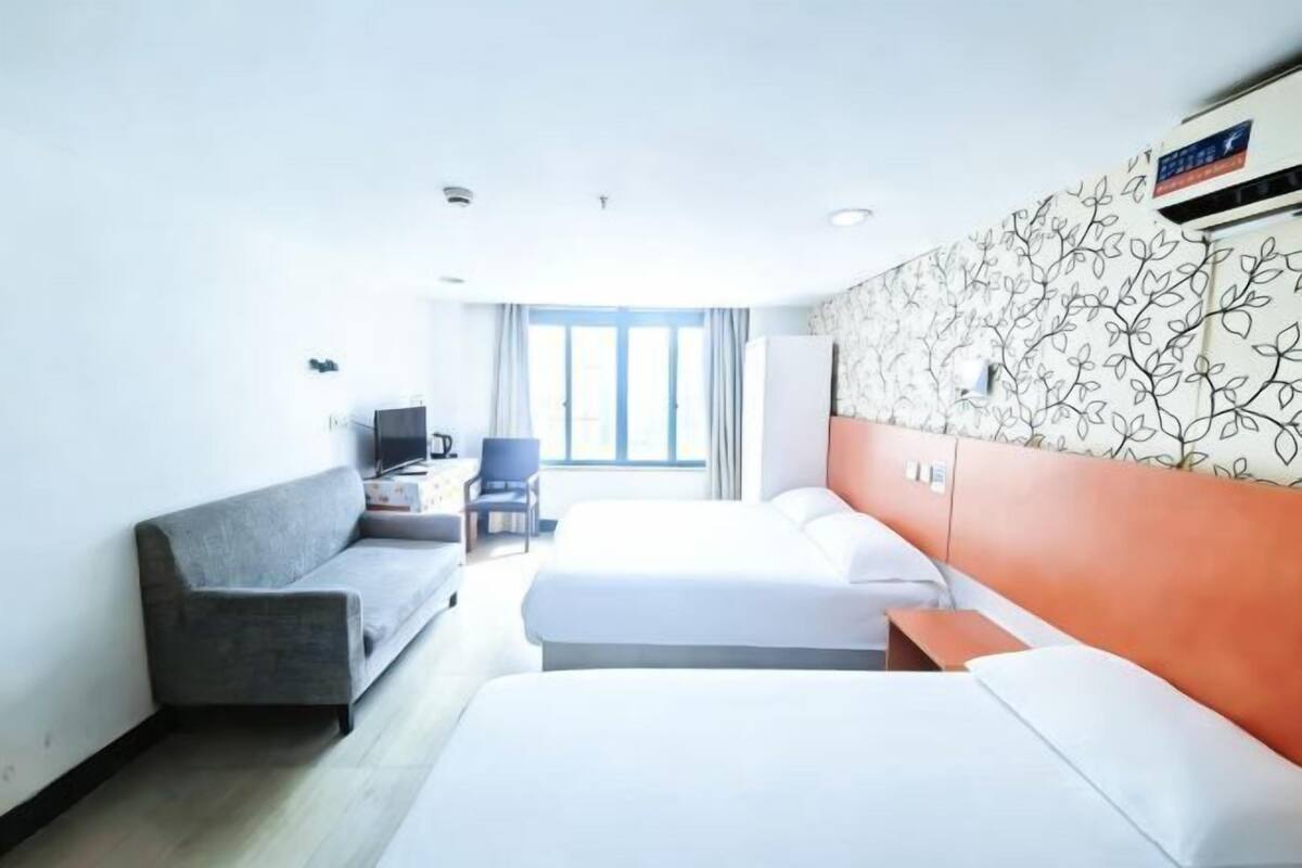 A hotel room with a bed, a sofa, a desk, and a chair.