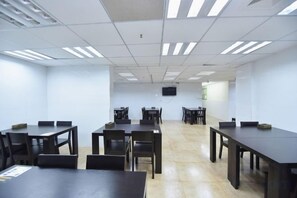 A conference room with multiple tables and chairs, a flat-screen TV mounted on the wall, and a tiled floor. - Citi Home Hotel (Hefei Datang International Shopping Plaza Honggang Subway Station) (Hefei)