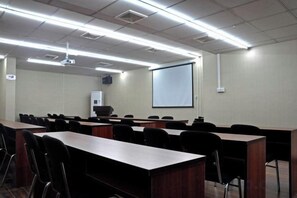 A conference room with rows of tables and chairs, a projector screen, and a whiteboard. - Citi Home Hotel (Hefei Datang International Shopping Plaza Honggang Subway Station) (Hefei)
