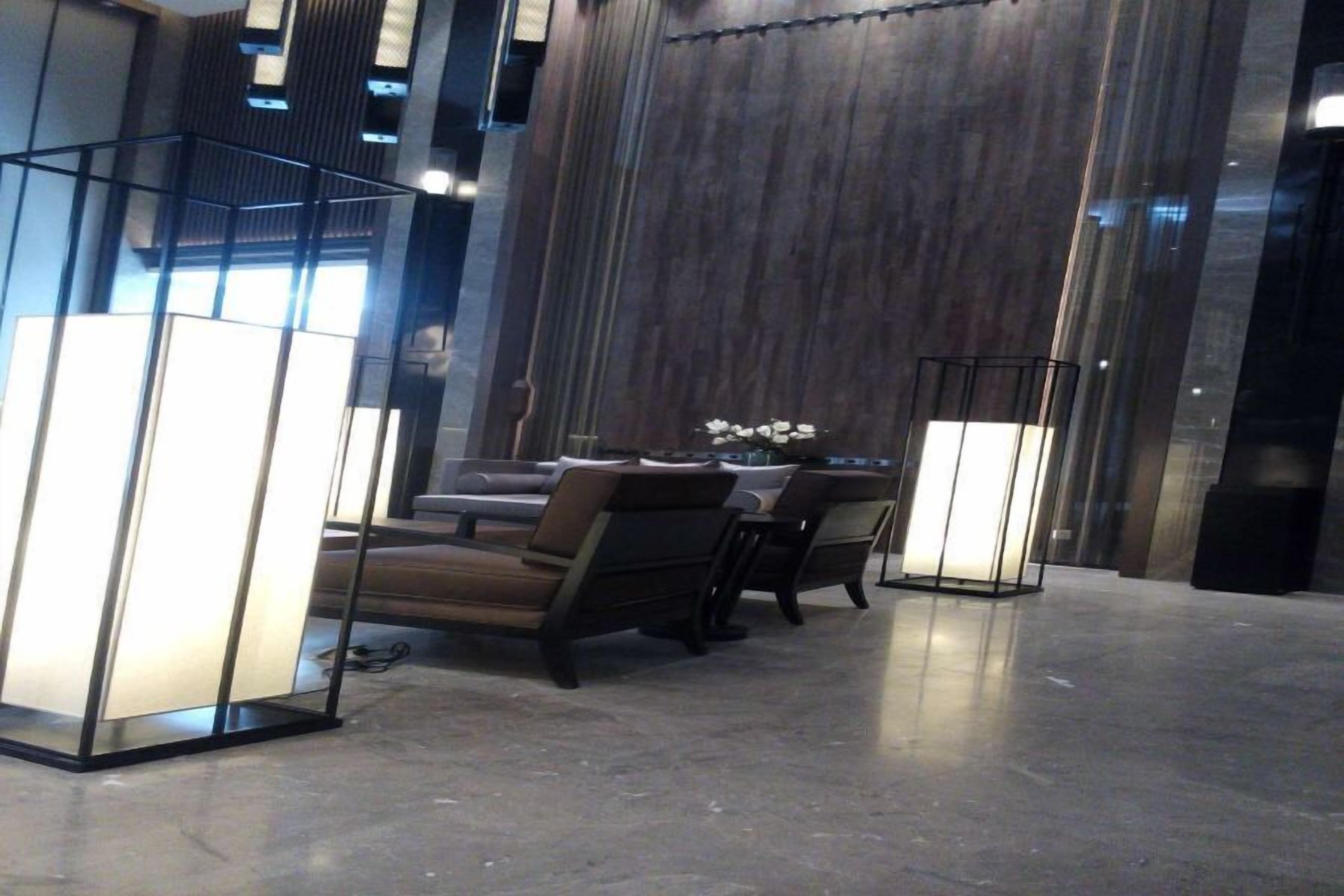 Un vestíbulo moderno con zona de estar, un gran panel de madera y una partición de vidrio.
