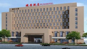 Un hotel con una fachada simétrica, numerosas ventanas y una entrada destacada.