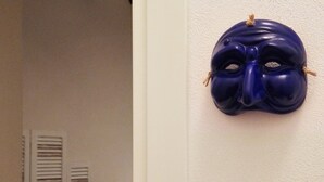 A room with a bed, pillows, a nightstand, and a wall-mounted mask. - Quartino Napoletano (Naples)