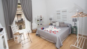 A bedroom with a bed, a bench, a bedside table, a lamp, and a drying rack. - Quartino Napoletano (Naples)