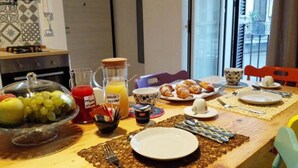 A breakfast table with fruits, juice, pastries, and a coffee cup. - Quartino Napoletano (Naples)
