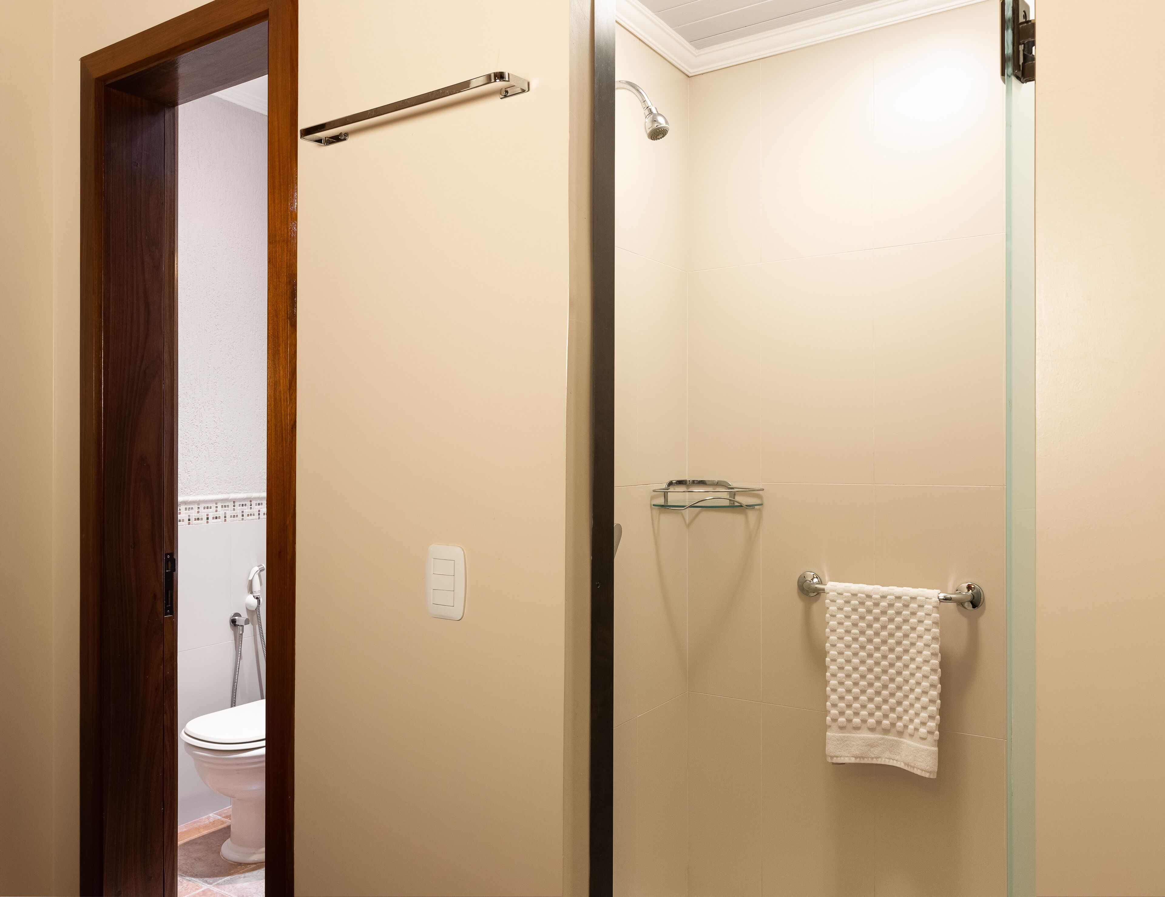 Un baño con inodoro, ducha y puerta de cristal.