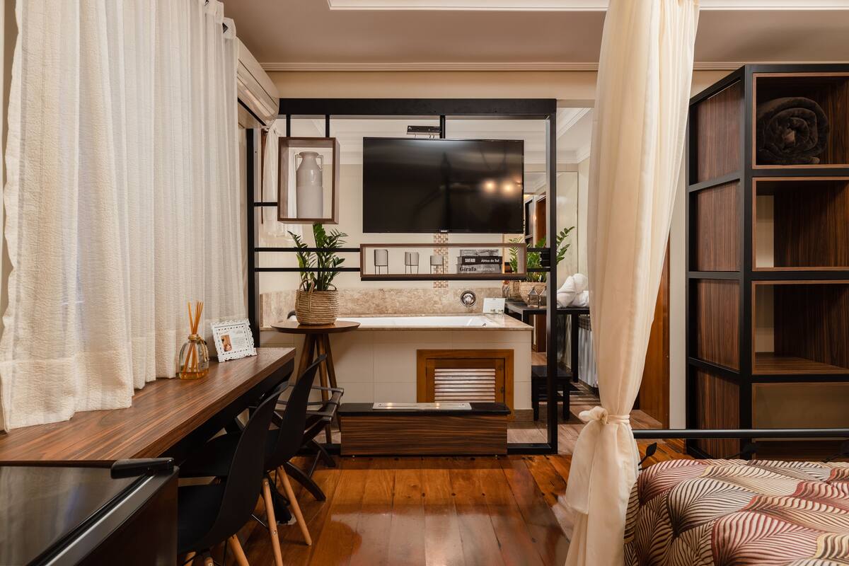 A compact living space with a kitchenette, a dining area, and a bed.