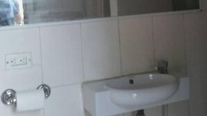 A bathroom with a white sink, a window above the sink, and a mirror. - Le Creole Hideaway (Jacmel)