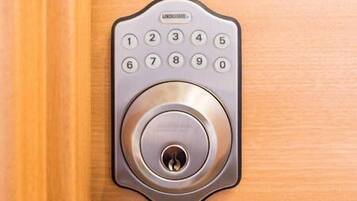 A numeric keypad lock on a wooden door.