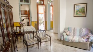 A dining area with a table and chairs, a sofa, and a painting on the wall. - Rio Antigo (Rio de Janeiro)