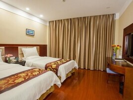 Habitación de hotel con dos camas, un escritorio y un ventanal grande con cortinas.