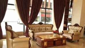 A living room with a sofa set, a coffee table, and a bookshelf. - Greentree Inn Chengdu Chongzhou Shiji Avenue Longt (Chengdu)