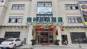 A hotel with a signboard displaying its name and a banner above the entrance.