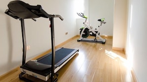 A room with a treadmill and an exercise bike.