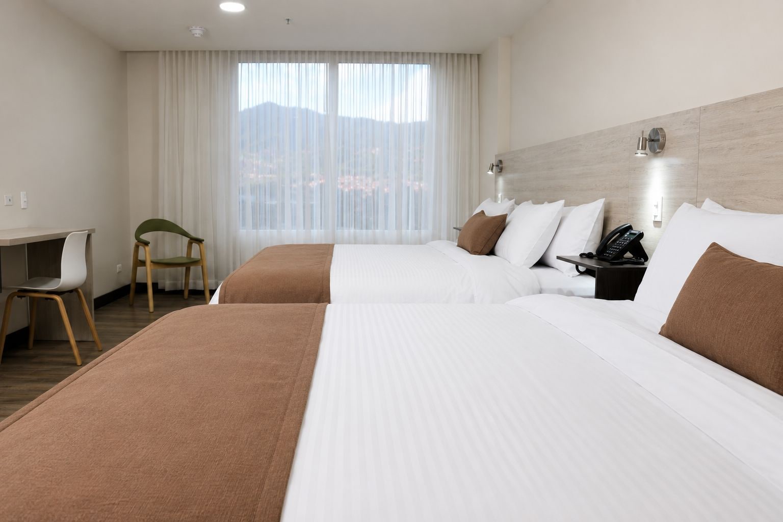 Una habitación de hotel con dos camas, un escritorio y una silla.