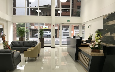 A modern reception area with a glass door entrance, a reception desk, and seating arrangements.