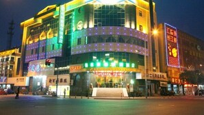 A hotel with a green sign, multiple floors, and a large entrance. - GreenTree Inn Suzhou Zhangjiagang Daxin Town Pingbei Road Express Hotel (Suzhou)
