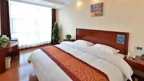 A hotel room with a large bed, a desk, a telephone, and a window with curtains. - GreenTree Inn BeiJing Haidian Shijingshan N Univ of Tech Htl (Beijing)