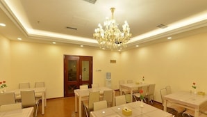 A conference room with multiple tables and chairs, a chandelier, and a wooden floor. - GreenTree Inn BeiJing Haidian Shijingshan N Univ of Tech Htl (Beijing)