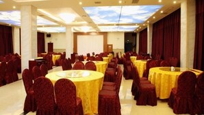 A banquet hall with round tables and chairs, a stage, and a presentation screen. - GreenTree Inn Prov. Suzhou Wuzhong Fengjin Rd Business Hotel (Suzhou)