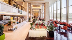 Un hall d’hôtel spacieux, doté d’un espace buffet, de grandes fenêtres et d’un aménagement intérieur moderne.