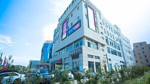 A multi-story hotel with a modern design, featuring large windows and a prominent entrance. - GreenTree Inn SuZhou International Film City South JinShan Road Express Hotel (Suzhou)