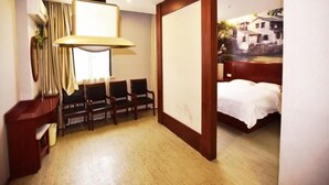 A hotel room with a bed, a desk, a chair, a lamp, and a view of a building through a window. - GreenTree Inn SuZhou International Film City South JinShan Road Express Hotel (Suzhou)