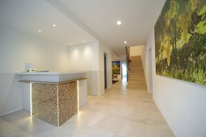 A modern reception area with a reception desk, a staircase, and a large wall mural. - Ristorante Hotel da Tullio (Tarzo)