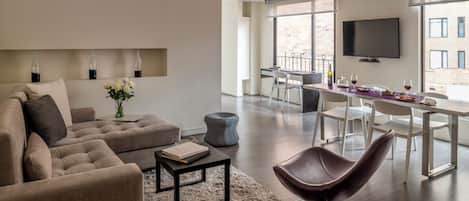 Una sala de estar moderna con un sofá, una mesa de centro y un comedor con una mesa y sillas.
