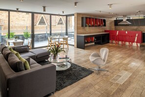 A modern living room with a sofa, chairs, a coffee table, and a fireplace. - Central Apartamentos Bogota (Bogotá)