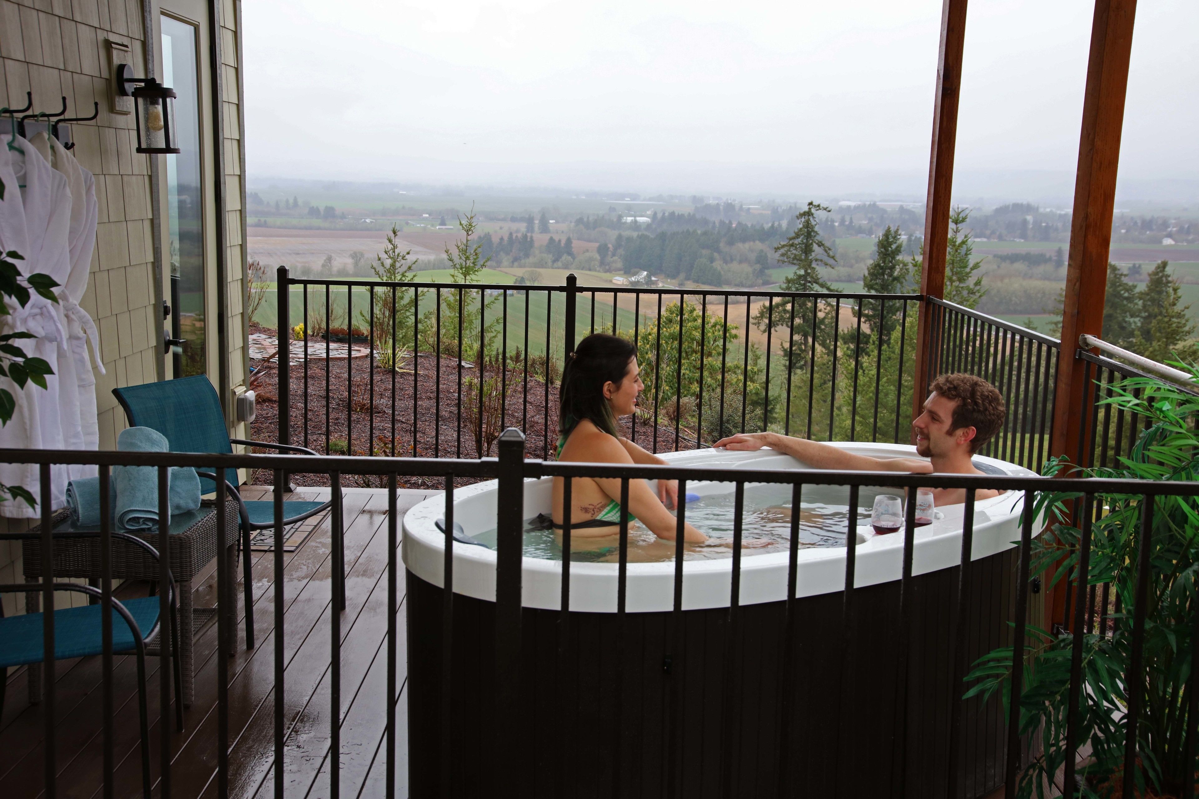 Ein Whirlpool auf einem Balkon mit Blick auf eine ländliche Landschaft.