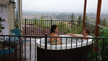 Ein Whirlpool auf einem Balkon mit Blick auf eine ländliche Landschaft.
