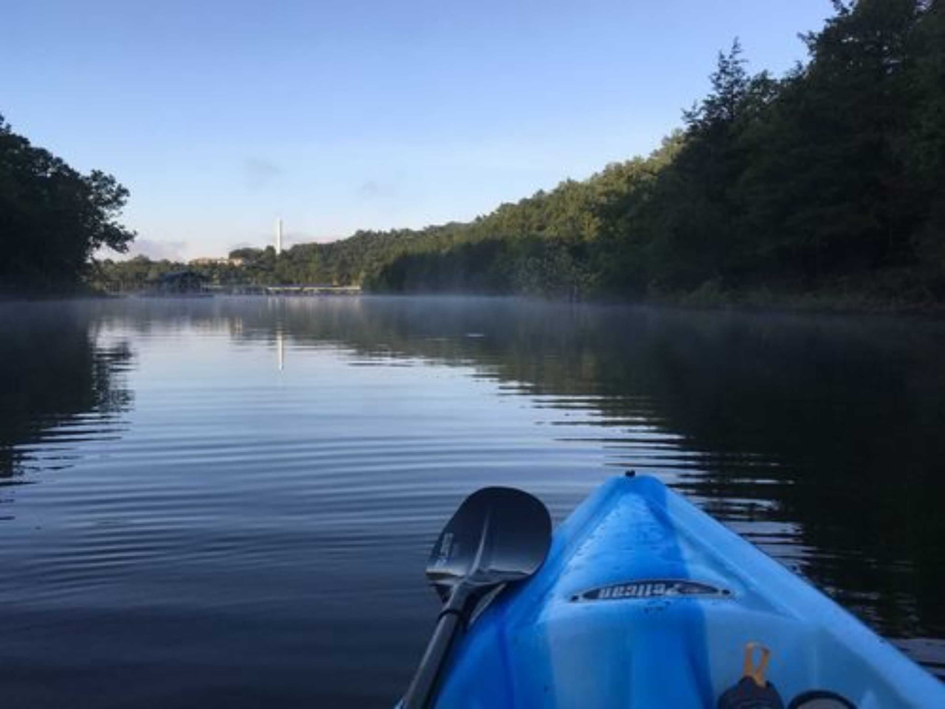 Un río tranquilo con un kayak amarrado a la izquierda.