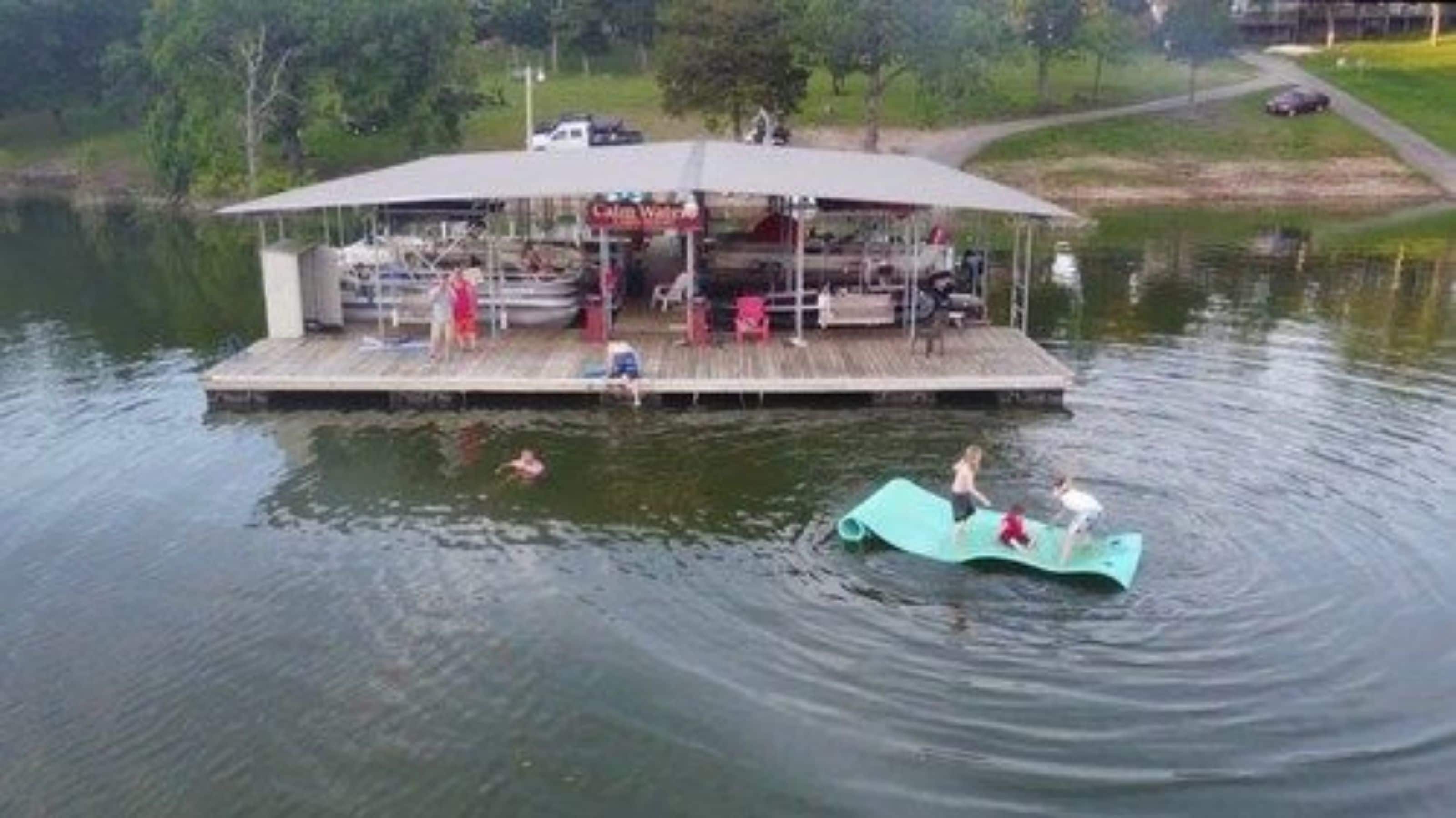 A docked boat with a covered seating area and a small pool.
