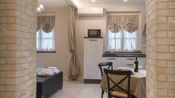 A cozy room with a dining area, a kitchen, and a built-in bench.