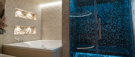 Un baño moderno con una bañera grande, una ducha con cerramiento de vidrio y azulejos de mosaico azul, y dos paneles de pared iluminados.
