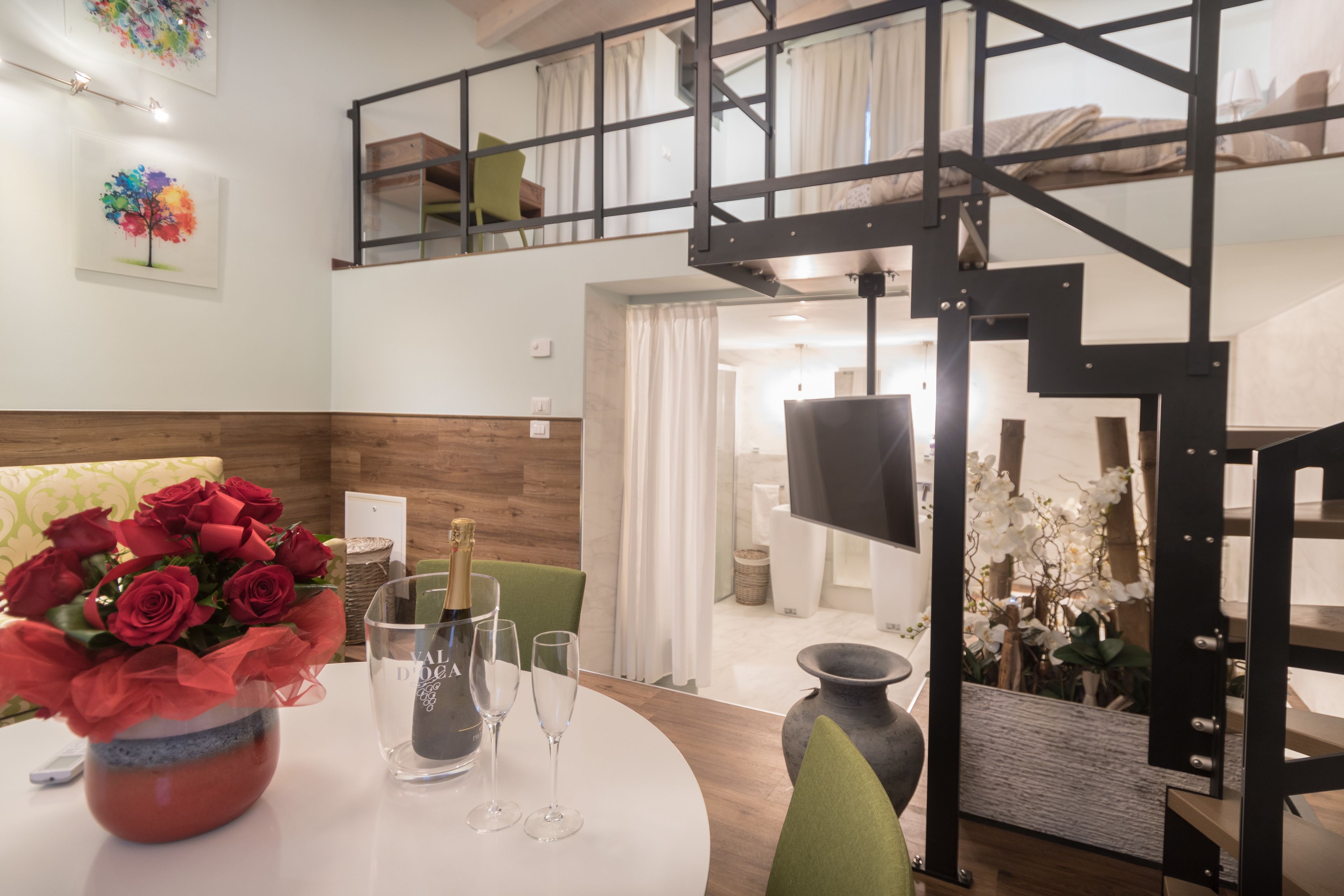 Una sala moderna con comedor, una escalera y un dormitorio en la mezanina.