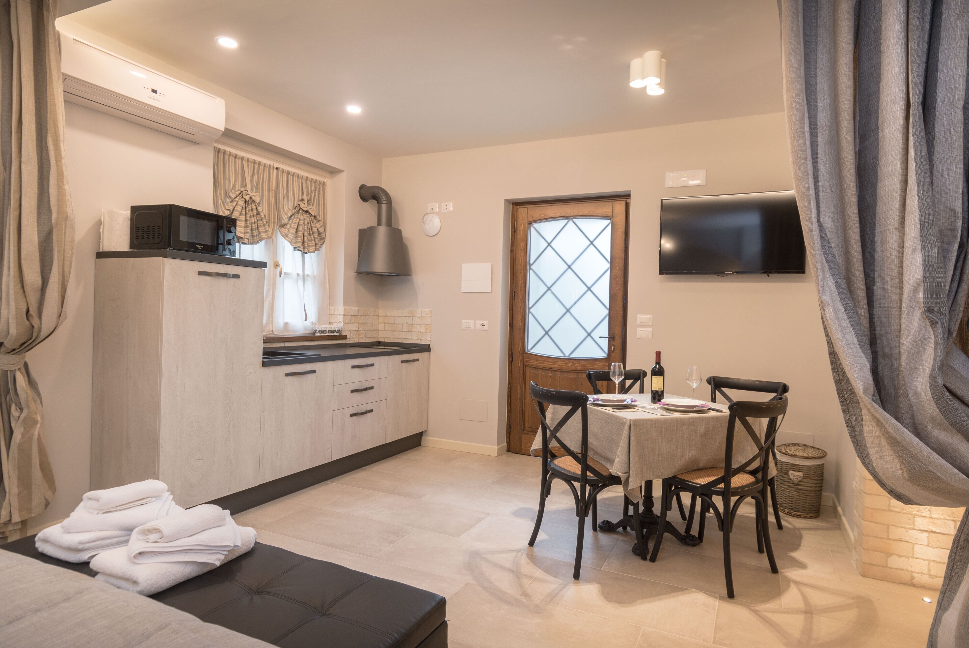 A compact kitchen with a microwave, stove, and a dining area with a table and chairs.