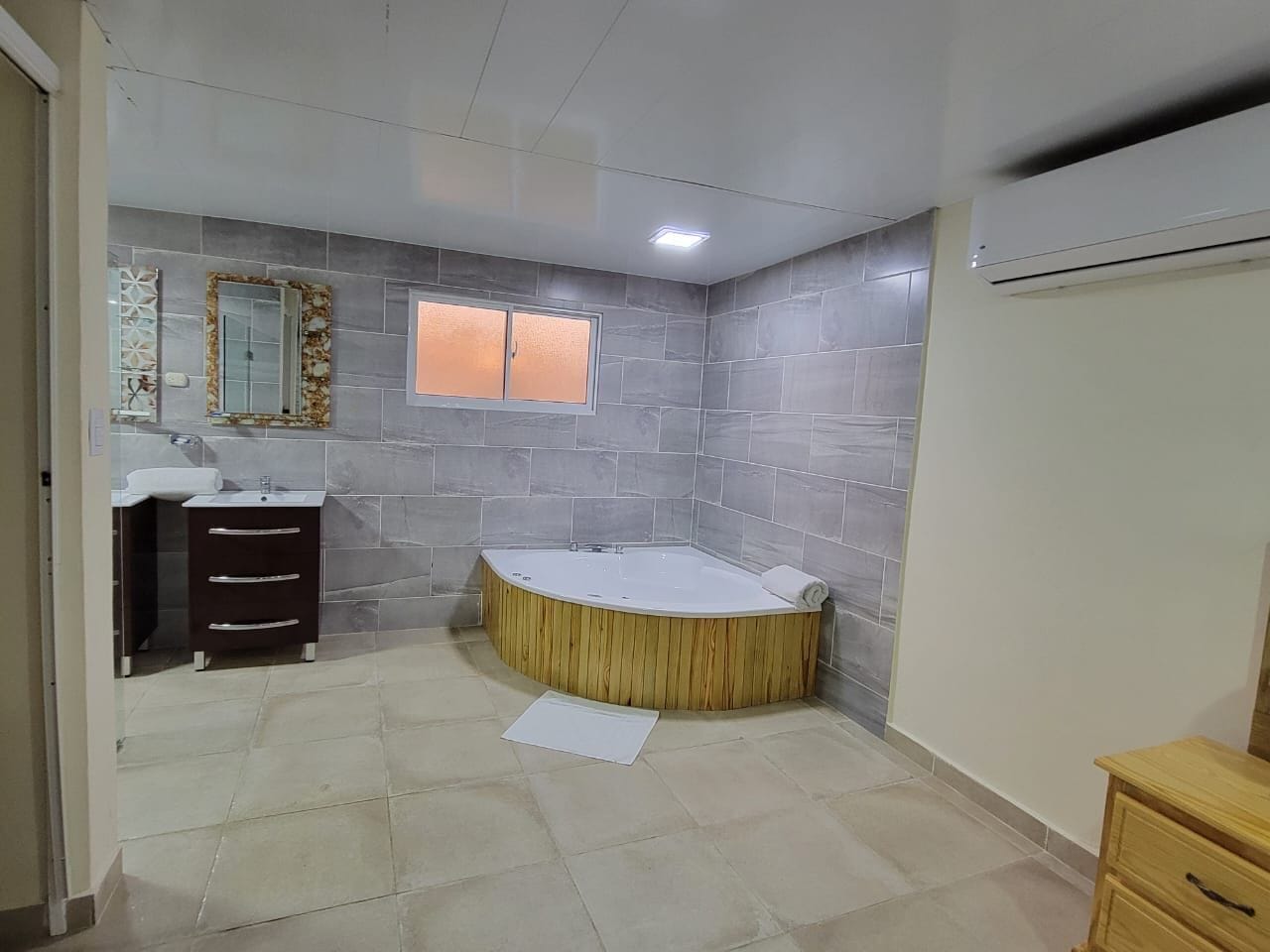 Une salle de bain avec une baignoire sur pieds, un meuble-lavabo avec un miroir et une fenêtre.