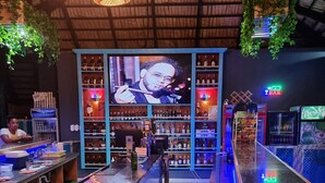 Een bar met flessenkast, een televisiescherm en een toog.