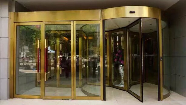 A revolving door with glass panels and gold accents. - Xining Xibai Hotel (Xining)
