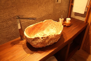 A stone sink with a wooden countertop and a towel rack in a bathroom. - Mi casa tu casa (Brusson)